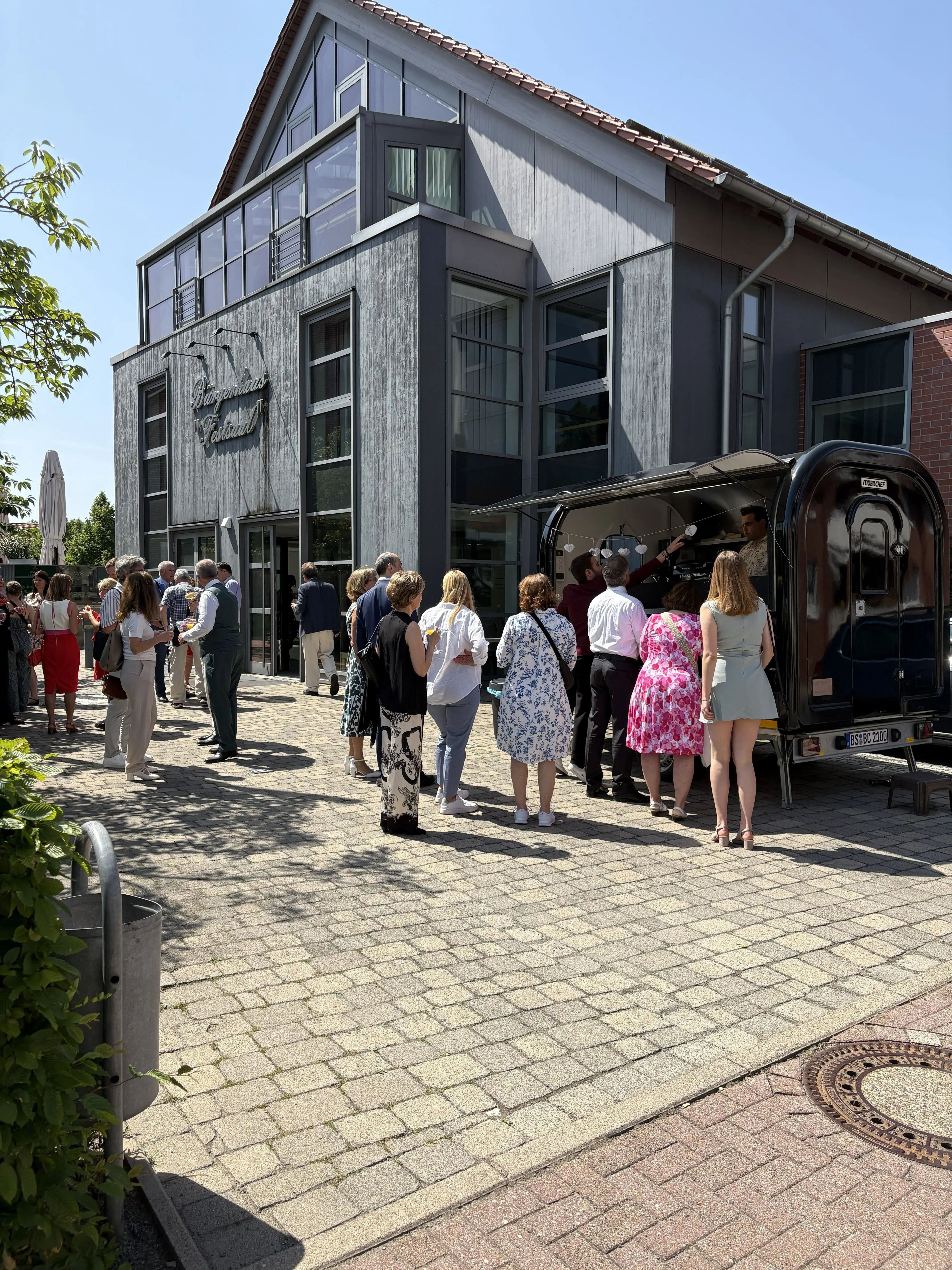 Gäste stehen vor einem Firmengebäude am Crêpe Diem Foodtruck an