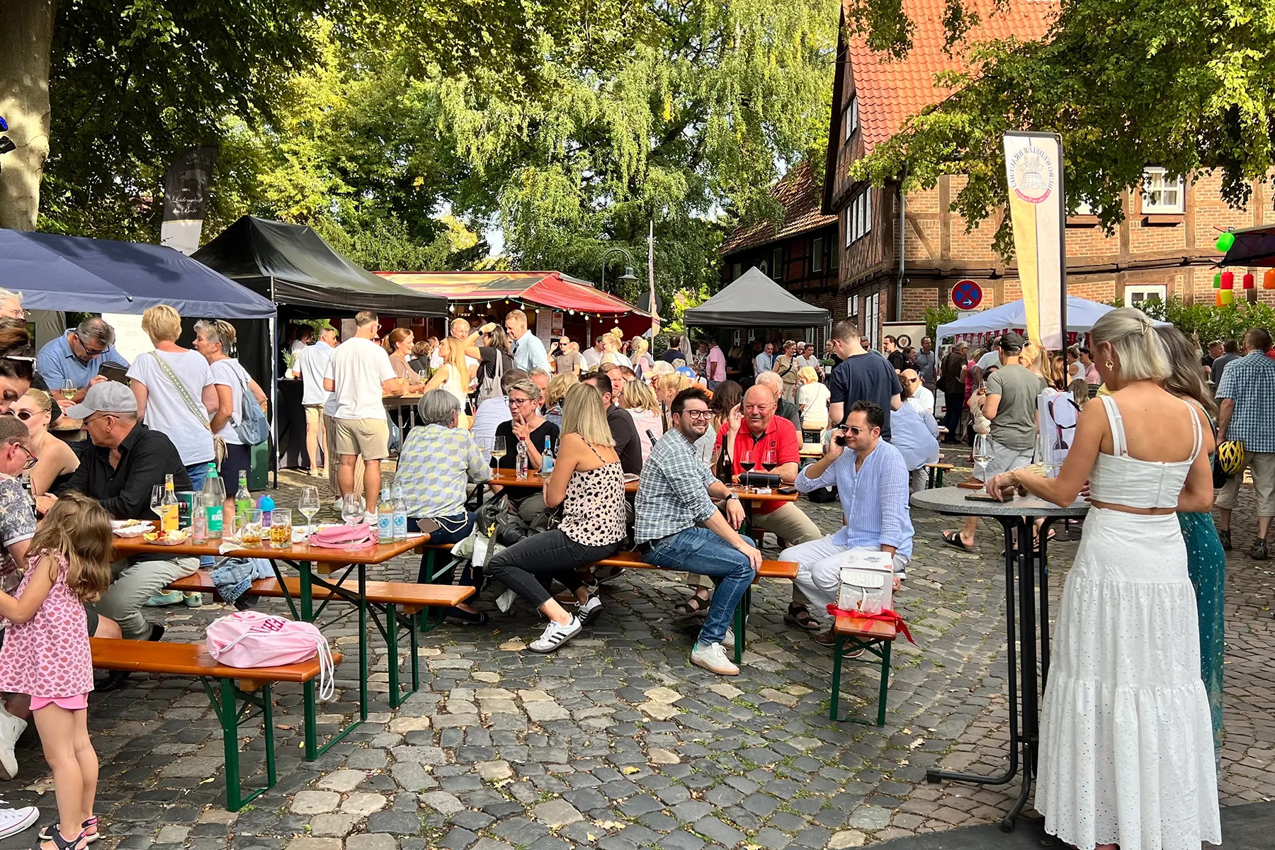 Gäste feiern gemeinsam an Biertischen im Freien